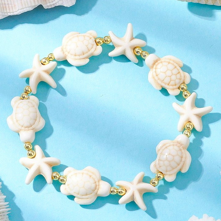 Bratara cu broasca testoasa si stea de mare turcoaz sintetic crem pe elastic si margele aurii-interior 5.5 cm 1 buc